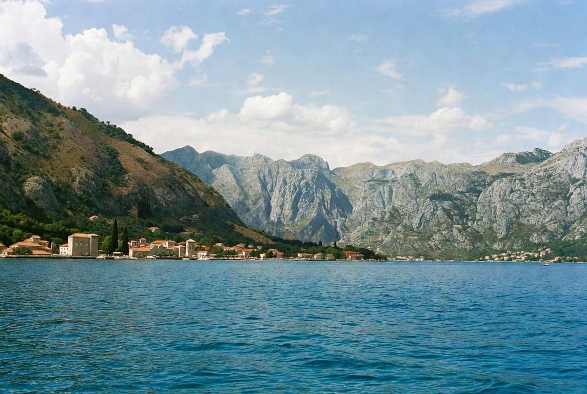 Kotor Bay Montenegro with medieval old town, blue Adriatic water, and surrounding mountains under clear sky
